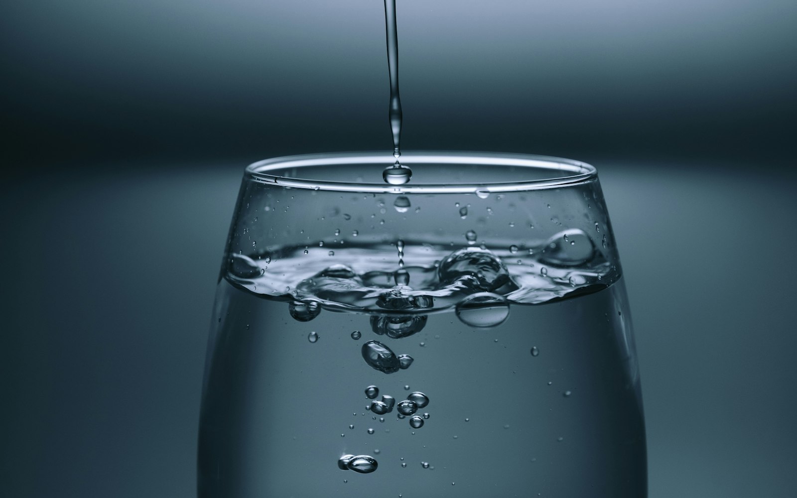 Agua cayendo en un vaso de cristal