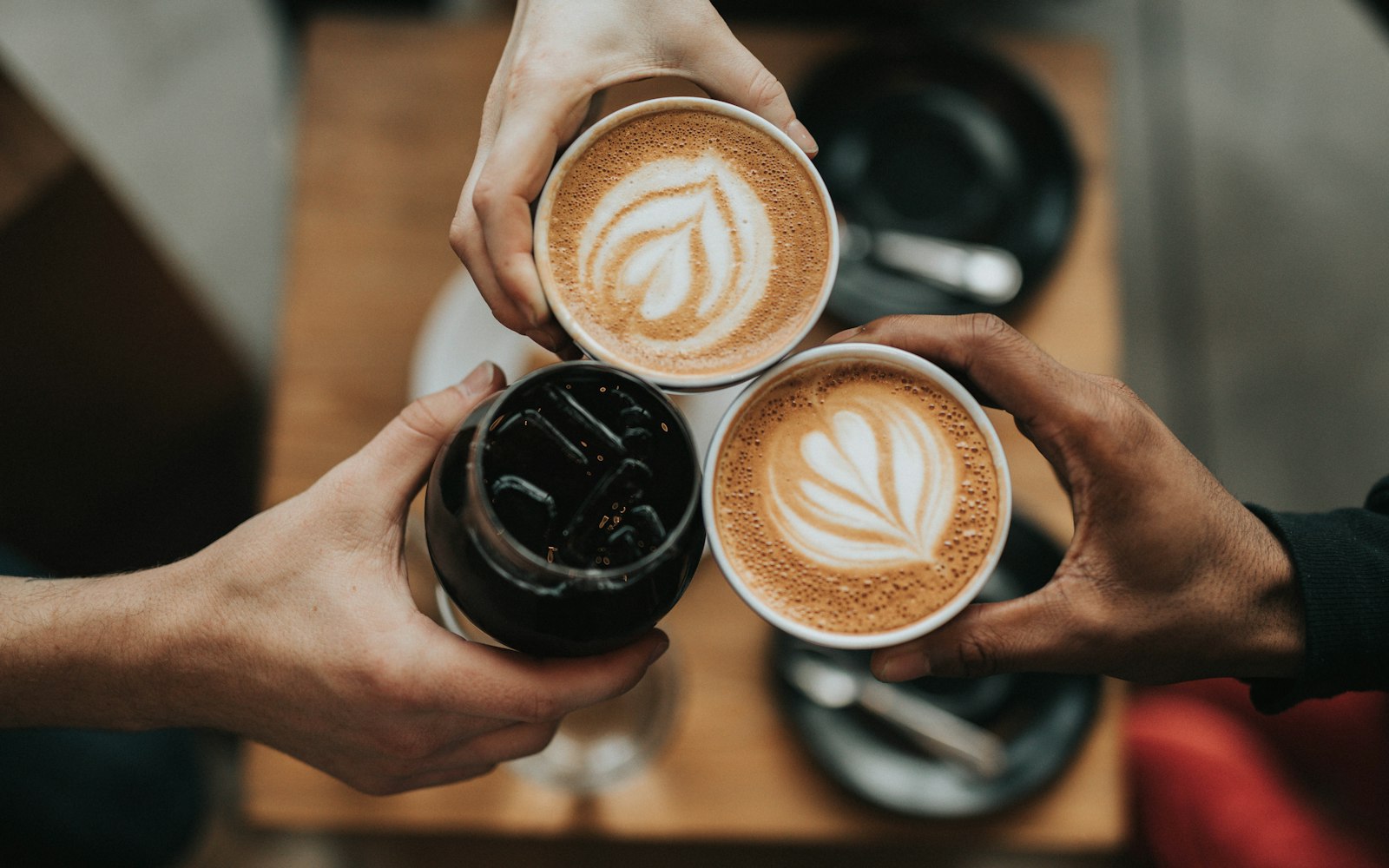Tres tazas de café juntas sobre una mesa de madera